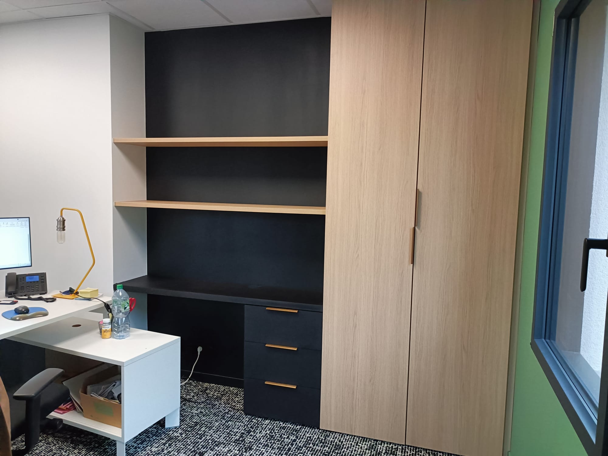 A Saint-Malo, aménagement de bureaux. Fabrication en MDF noir teinté dans la masse et panneaux imitation chêne. par Hugo Pauchard - HP Bois Menuiserie - Saint-Malo